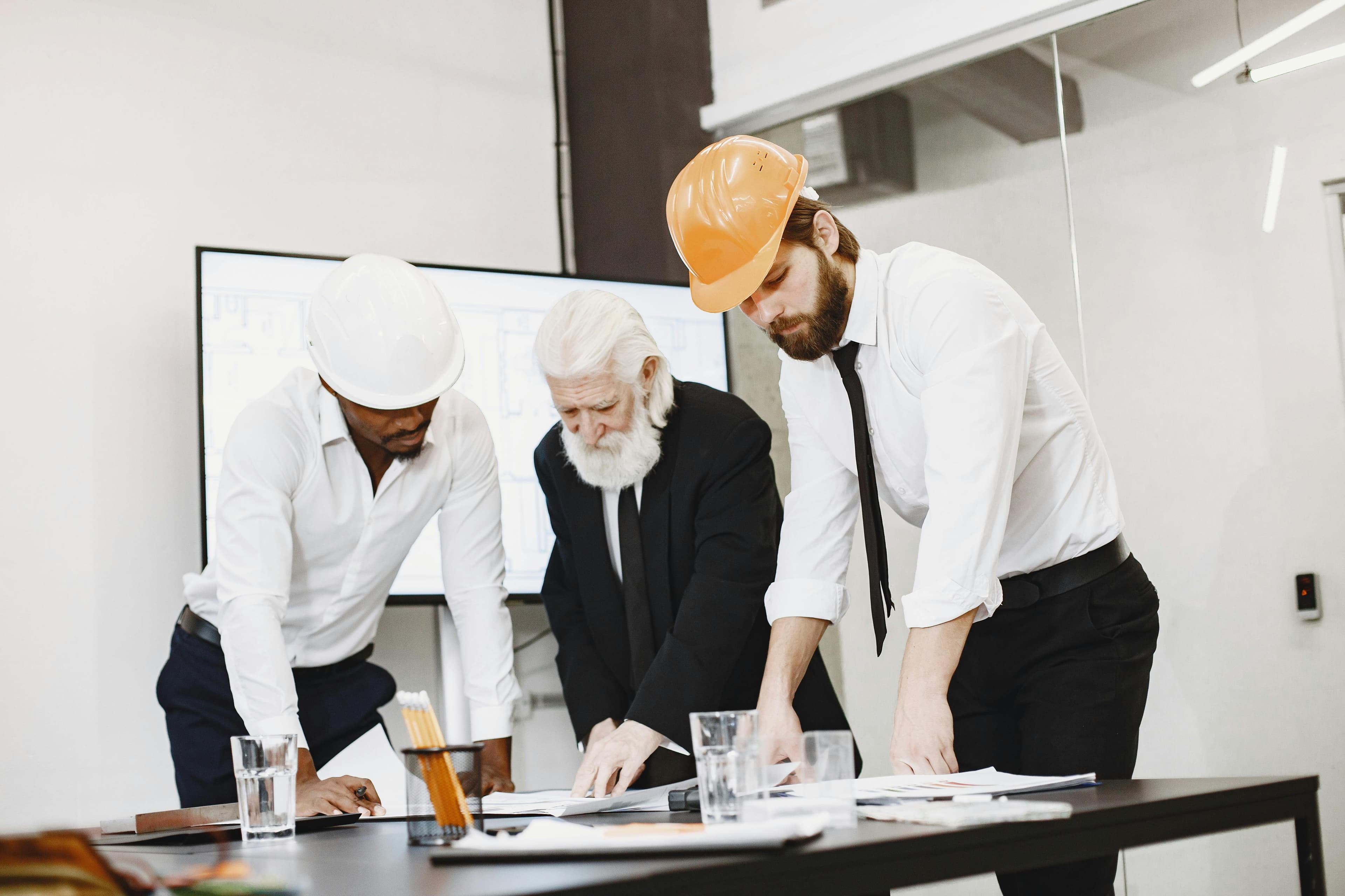 Construction professionals reviewing blueprints in an office