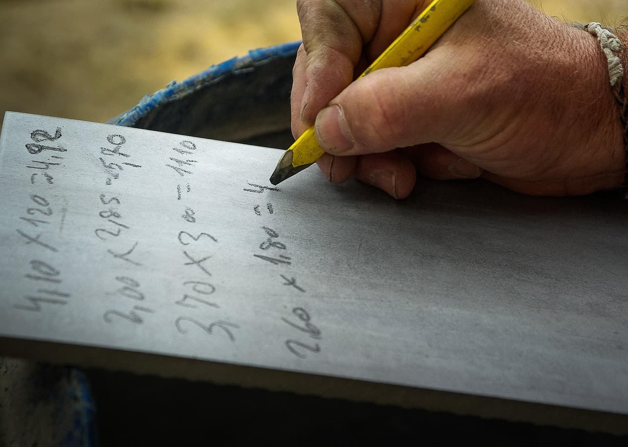 Builder checking measurements and costs on site for an accurate construction estimate